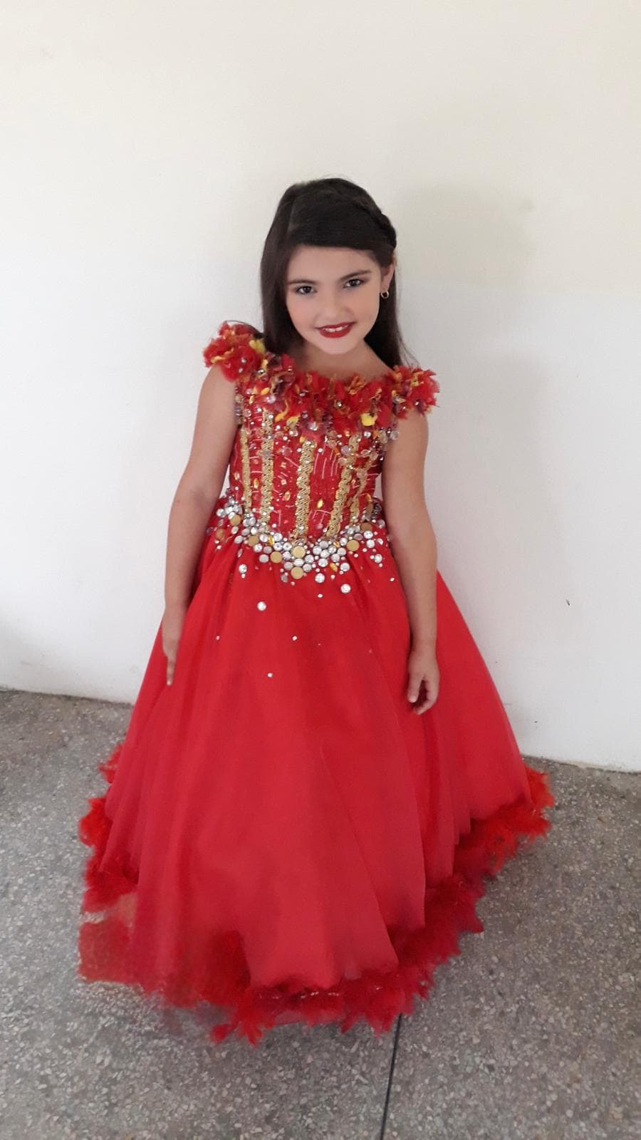 Ivana Oquendo as a little girl in a red dress for her quinceañera celebration